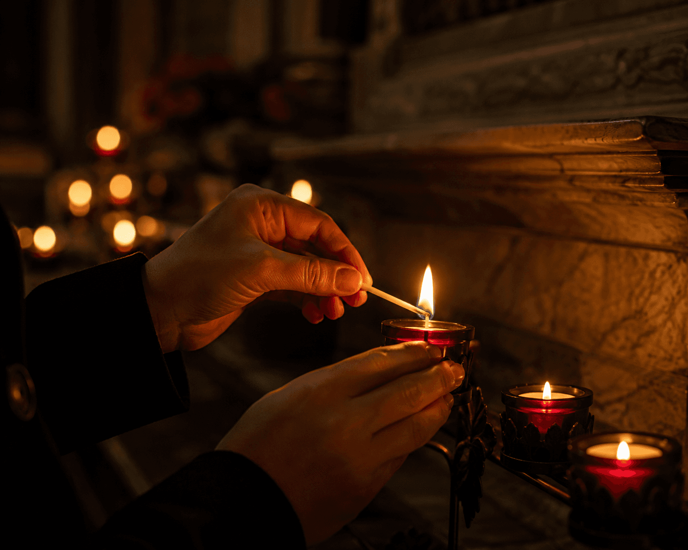 Hands lighting a candle in prayer